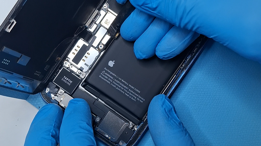 technician replacing iphone 13 battery disconnecting from phone zeero bg