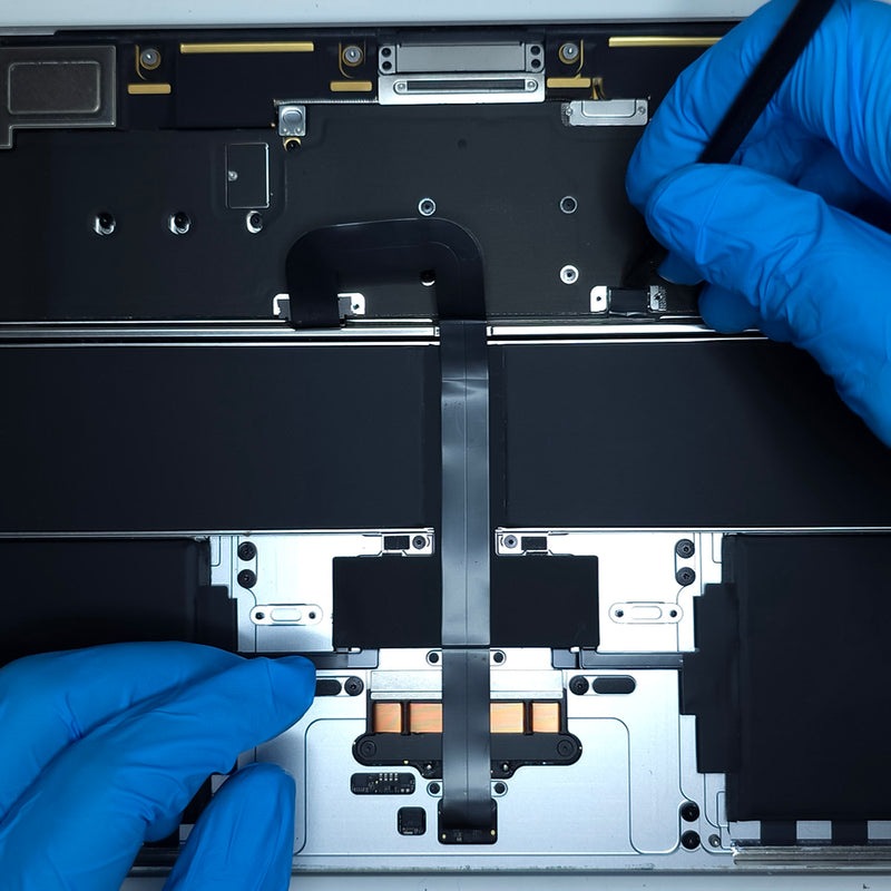 technician with blue gloves working on an open macbook air, genuine apple battery visible inside, being disconnected from the motherboard