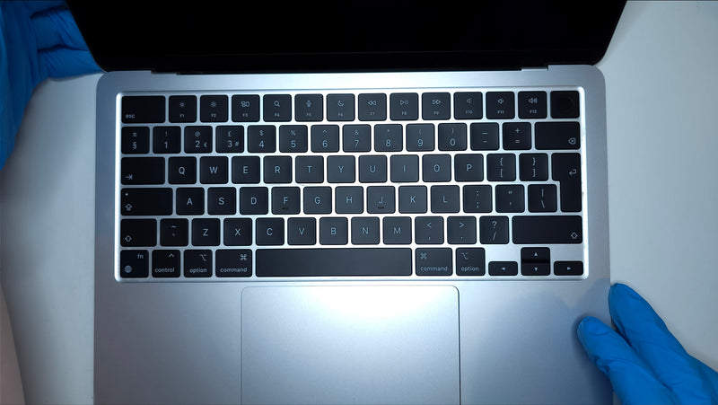 technician inspecting new original macbook air keyboard after replacement