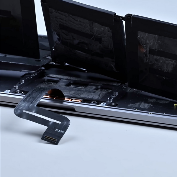 old swollen macbook laptop battery being removed in order to be replaced with a new original battery