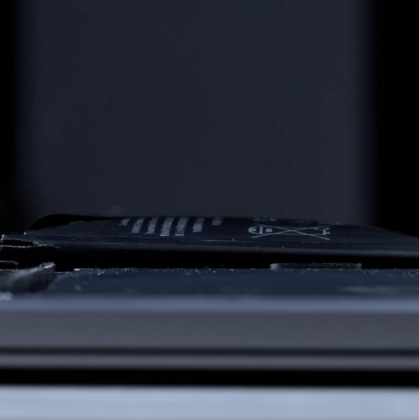 close-up shot of a swollen macbook battery and an expanded center cell