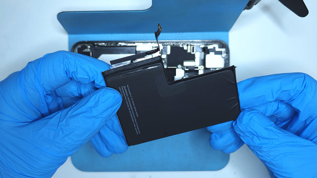 zeero technician holding old non genuine iphone battery from customer's phone